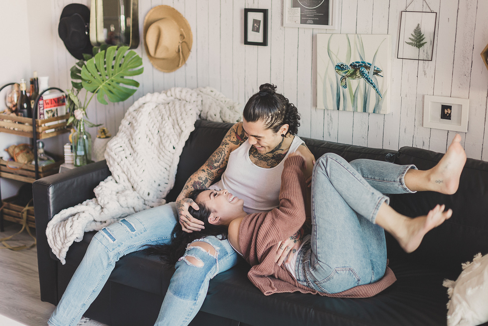 couple relaxes at home on couch during lifestyle portraits with Taylor Made Photography